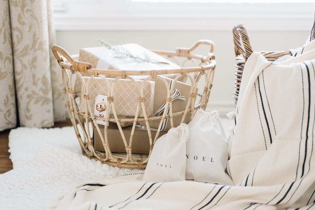 A rattan basket filled with presents wrapped in brown paper