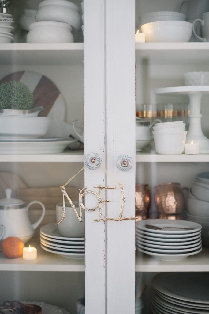 Noel ornament hanging on hutch knob handles