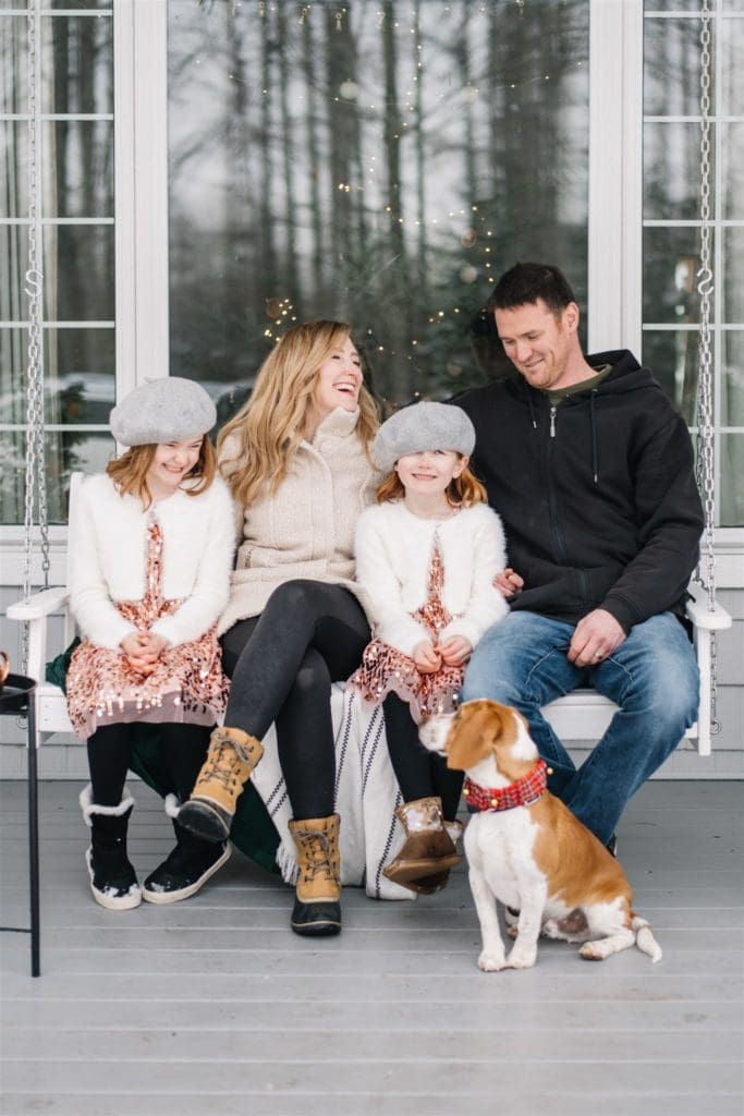 A family sits on a bench with a dog