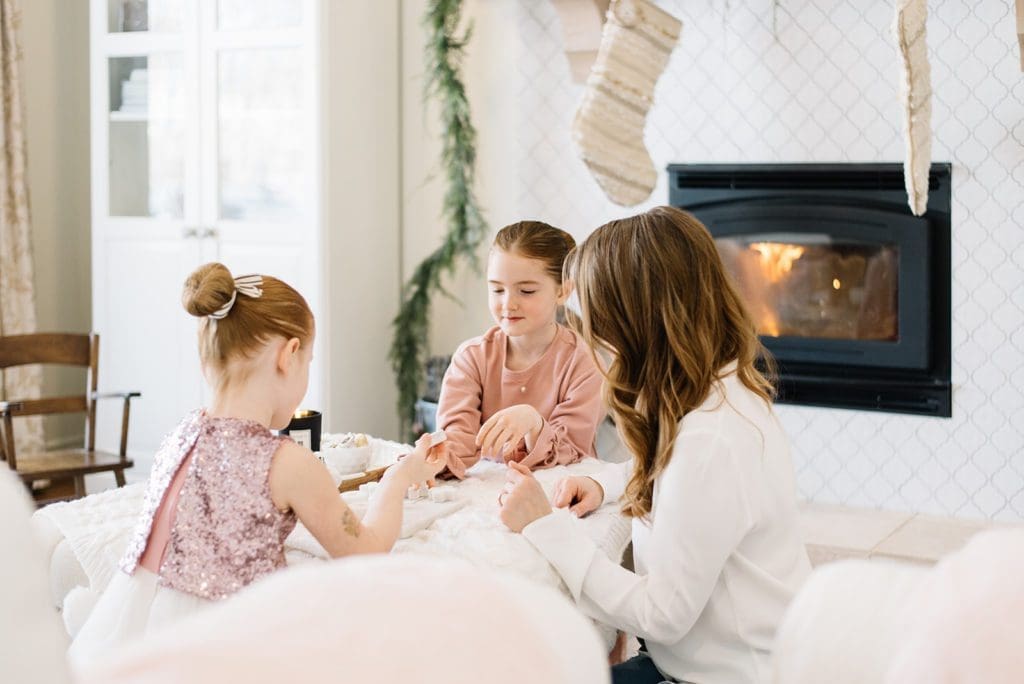 A woman and girls playing a game at Christmas