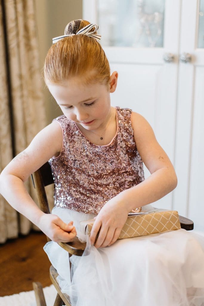 Little girl opening a Christmas gift