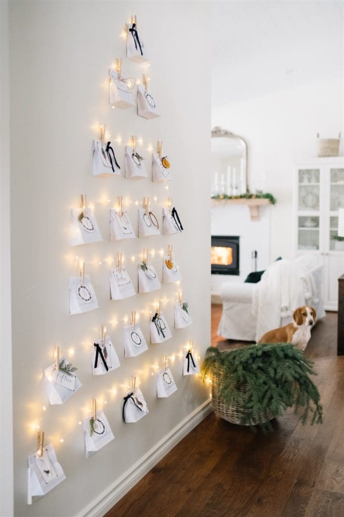 Christmas advent calendar on wall made from paper bags and twinkle lights