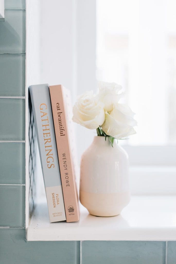 vase of roses and books on a ledge