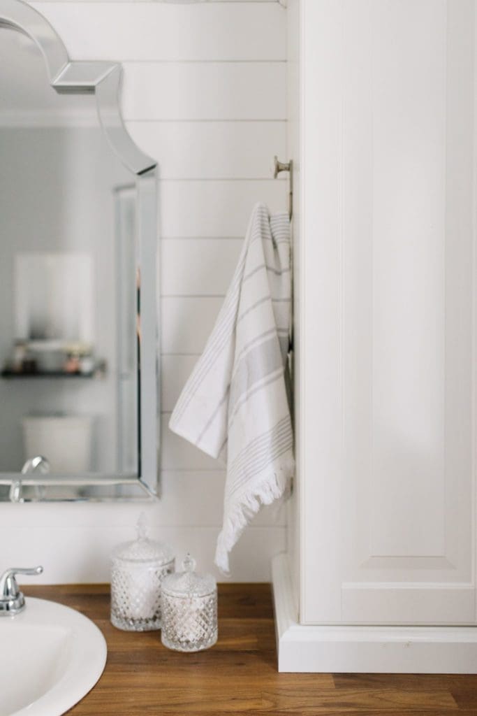 towels are hung on the side of cabinets in master bathroom