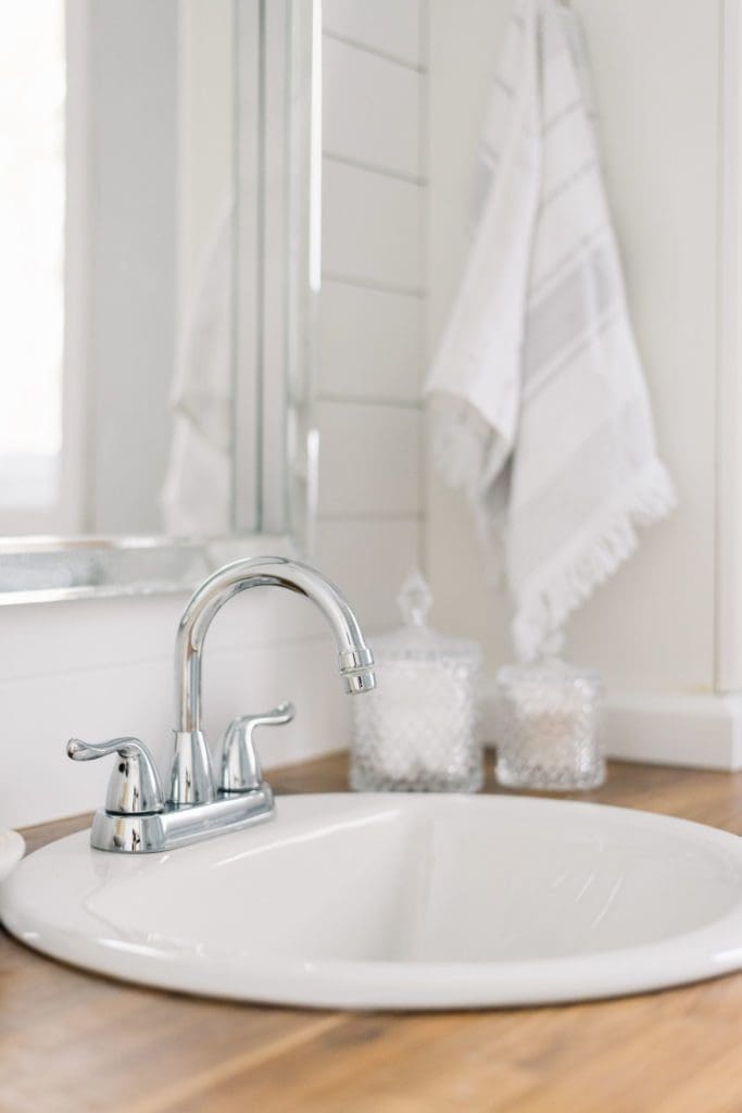 A small round sink in a tiny master bathroom