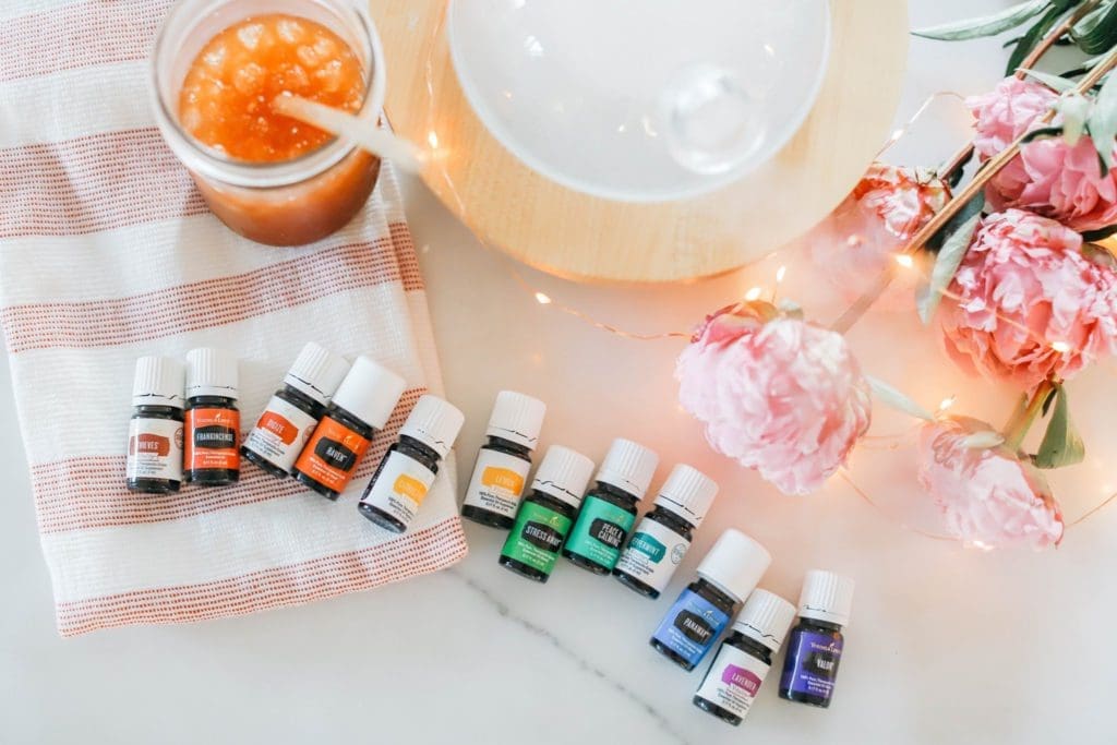 a rainbow of essential oils in front of a glass diffuser