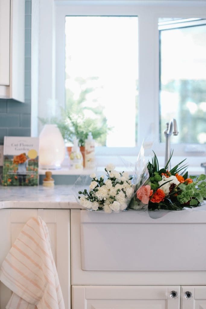 grocery store flowers in plastic wrap sitting in the kitchen sink