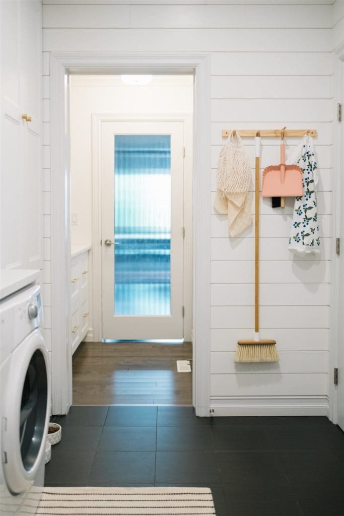 peg rail with brooms and utility items hung up