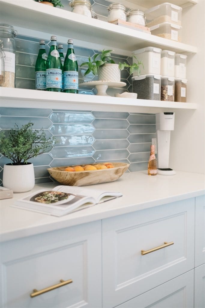 Pantry space with built in cabinets and tile backsplash
