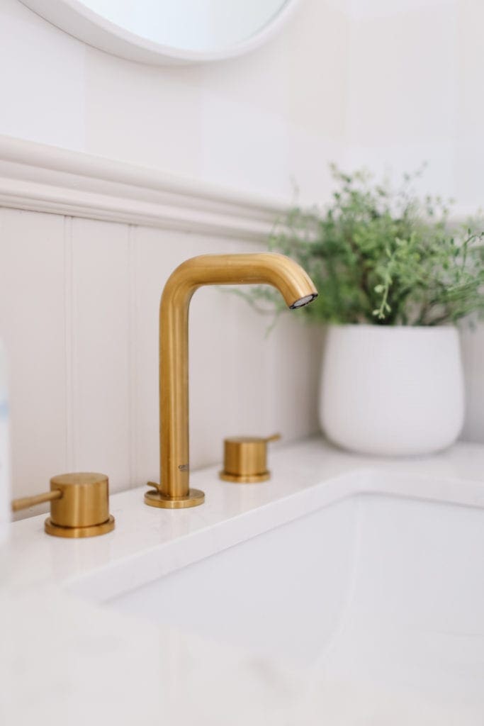 A close up of a brass bathroom faucet