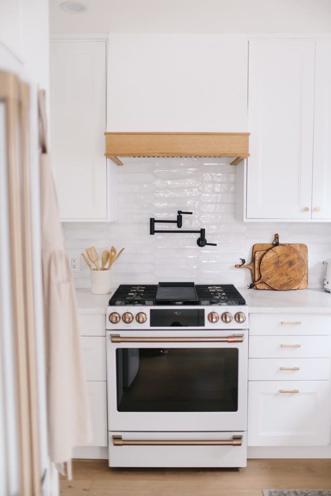 A Café Appliances stove in white and gold finishes