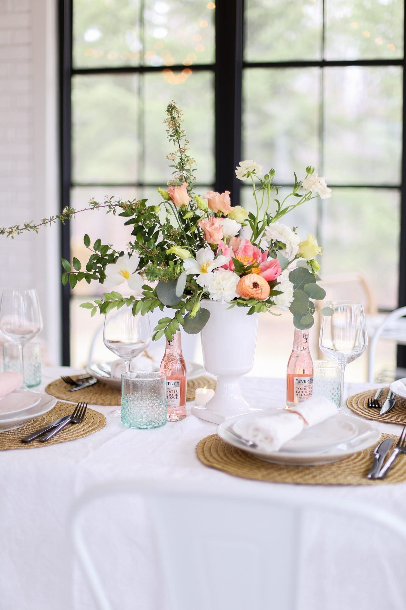 A vase of flowers on a mother's day tablescape next to a window